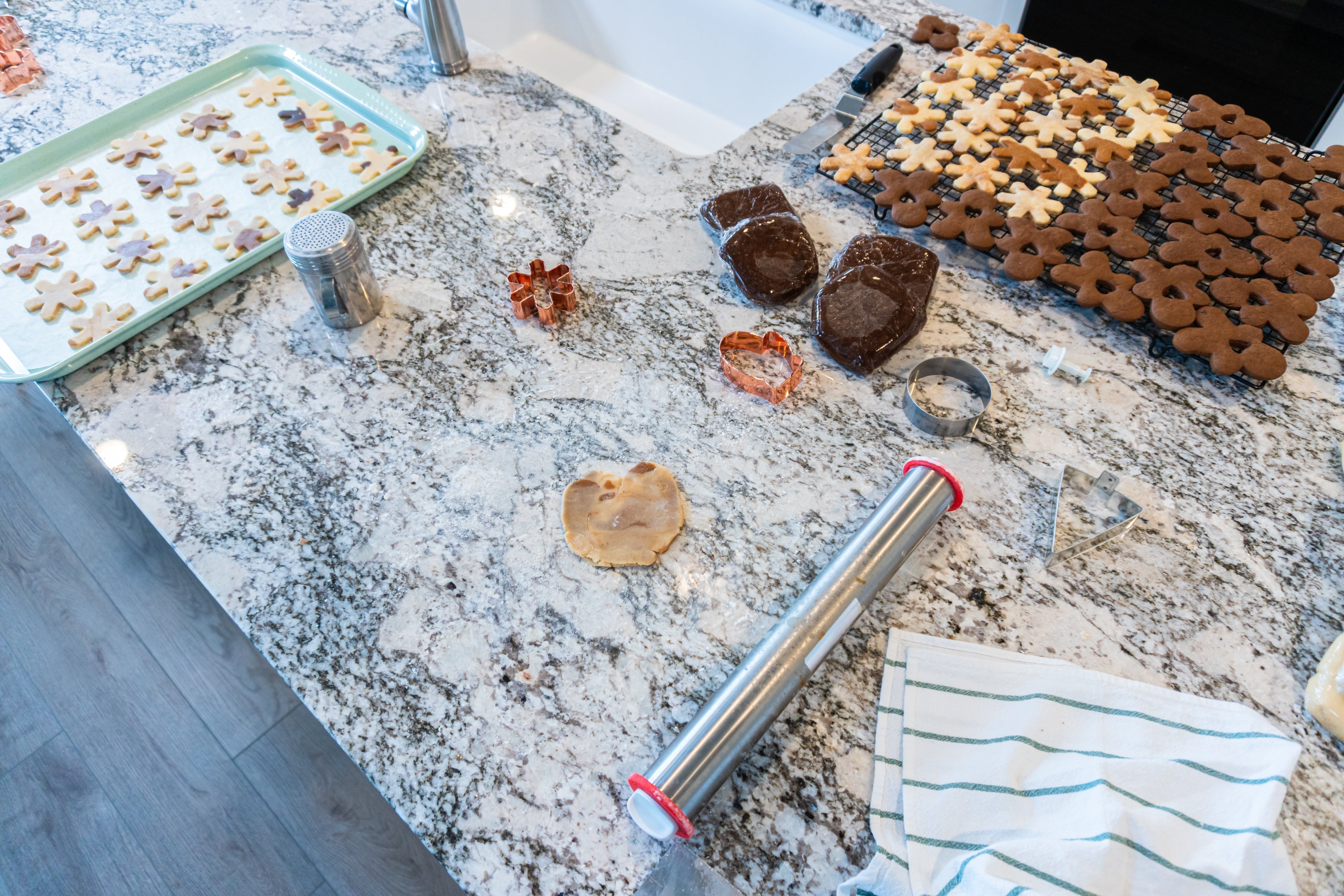 Baking cookies on a beautifully patterned granite countertop with various cookie shapes and tools.
