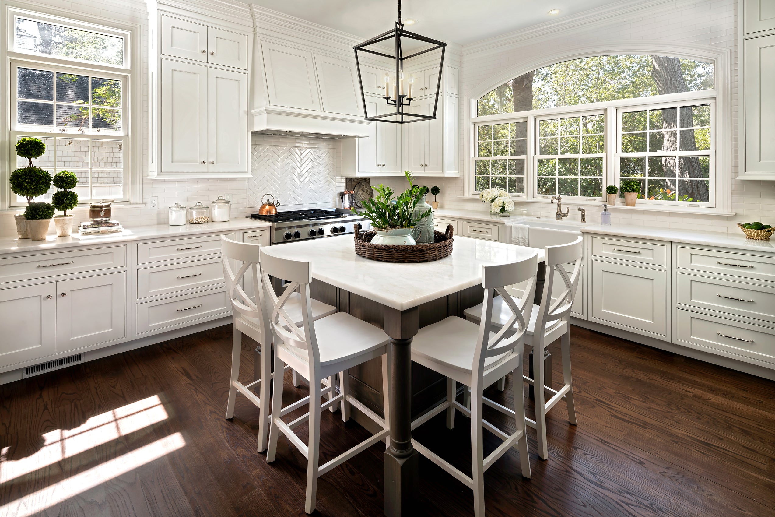 Bright kitchen featuring Shiloh white cabinets, a spacious island, and stylish bar stools, perfect for custom designs.