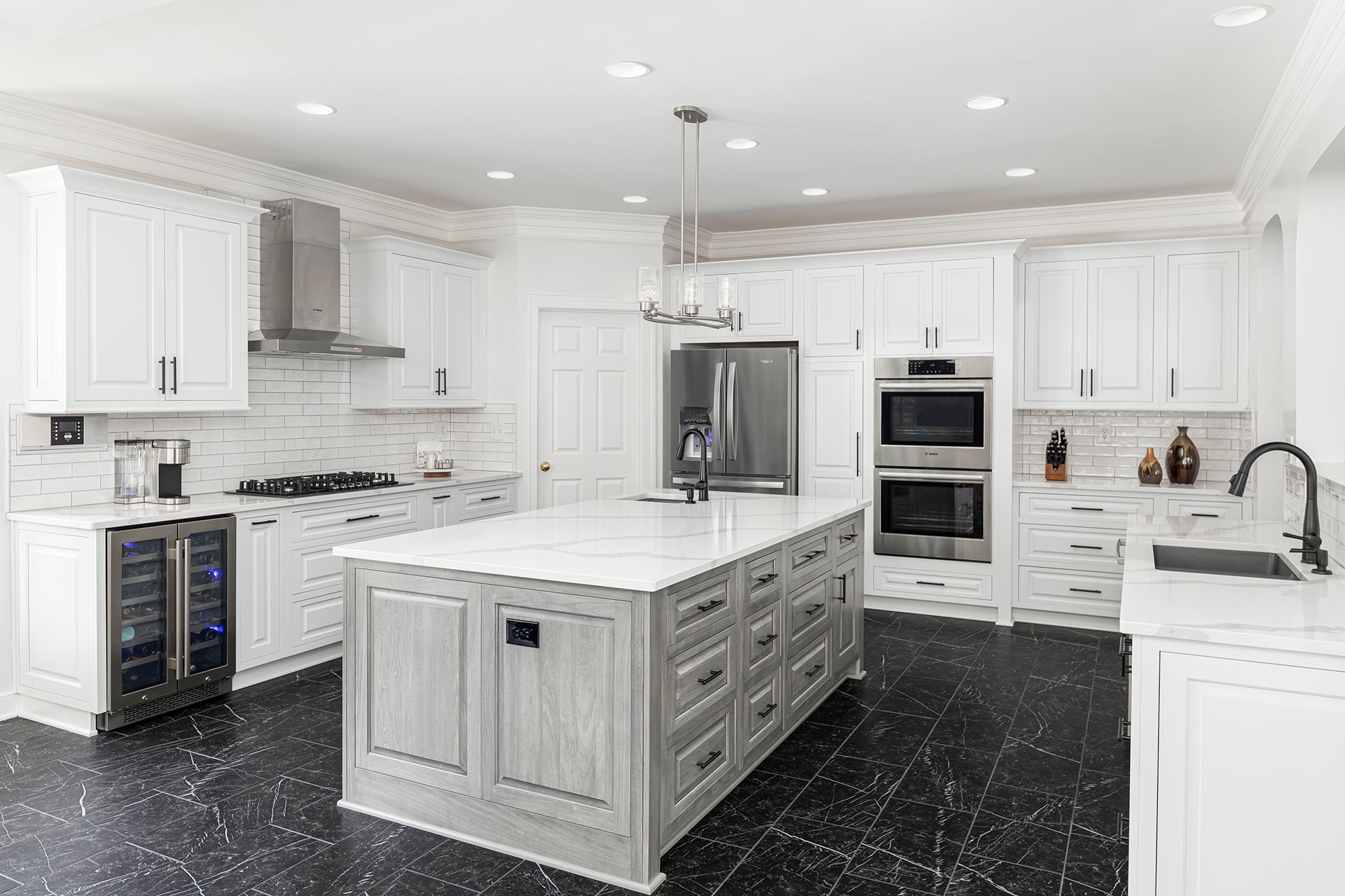 Modern kitchen featuring Shiloh cabinets in white and gray with a spacious island and stainless steel appliances.