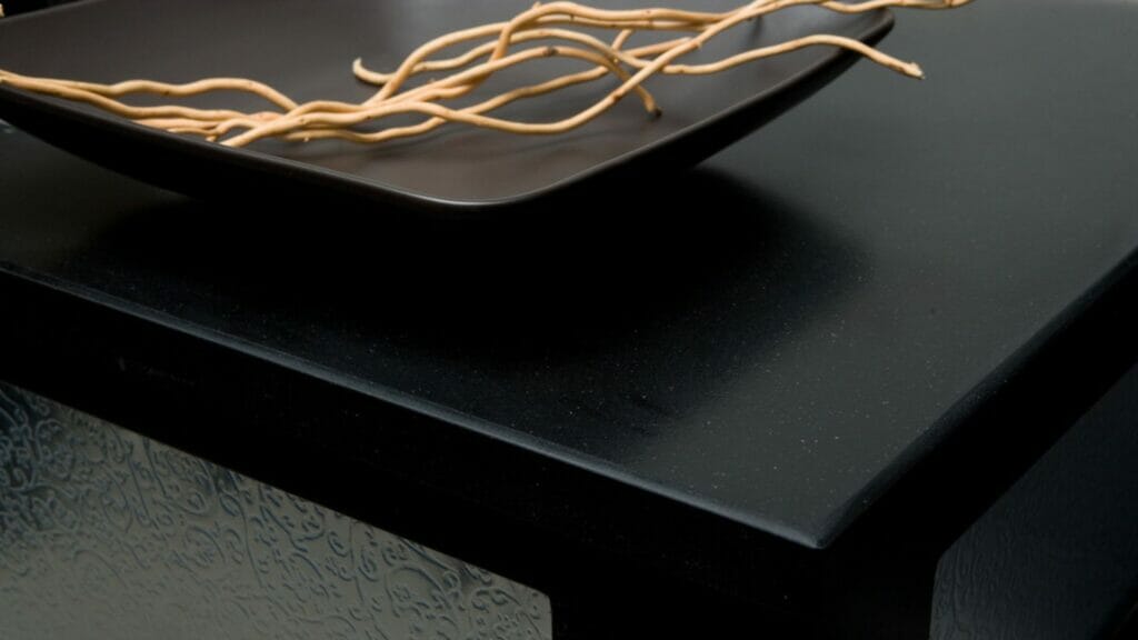 3100 Jet Black surface with sleek design, highlighted by a decorative bowl and elegant twigs for a luxurious aesthetic.