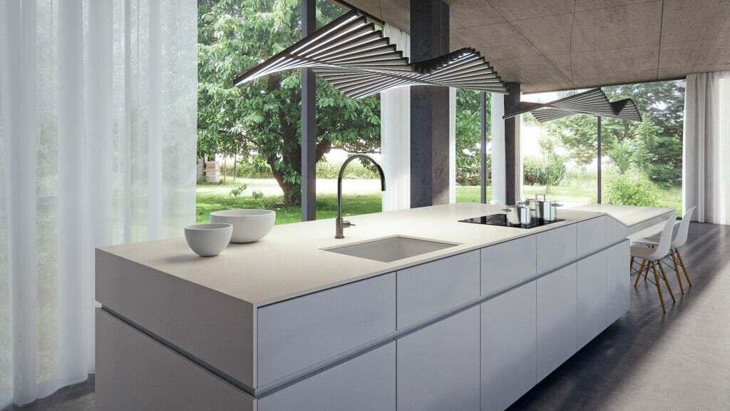 Modern kitchen design featuring a sleek white concrete island with elegant fixtures and ample natural light.