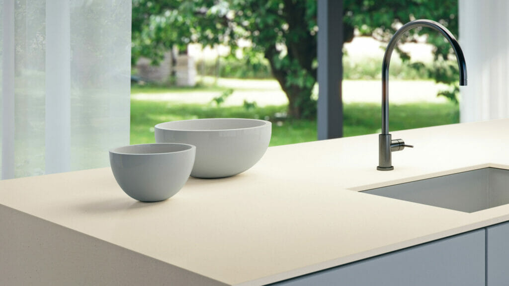 Modern kitchen countertop featuring fresh white concrete with subtle grey bowls and a sleek faucet.