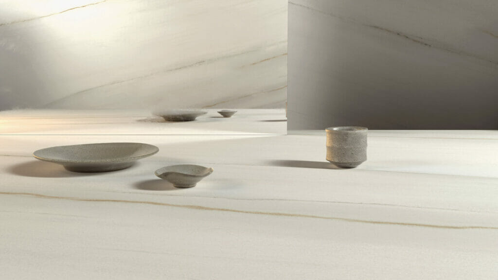 Elegant tabletop featuring minimalist ceramic dishes on a soft white and grey surface, highlighting subtle textures and layers.