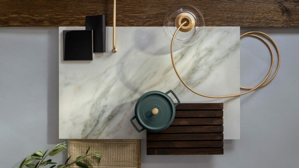 Sophisticated ivory-white countertop with grey veins and green accents, styled with cookware and decor for a contemporary kitchen.