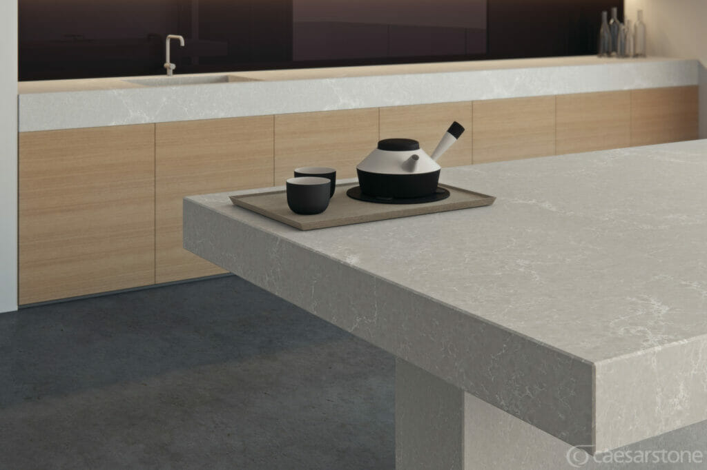 5110 Alpine Mist countertop showcasing cool grey with white veins and dark flecks, styled with modern dishes.