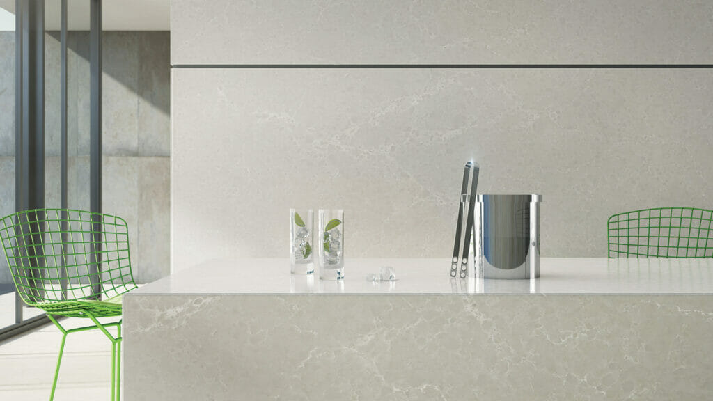 5110 Alpine Mist countertop with cool grey background, white veins, and green chairs in a modern kitchen setting.