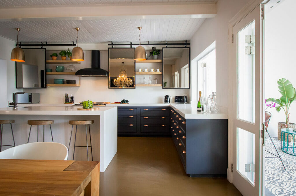 Modern kitchen with ivory and grey decor, stylish bar stools, and elegant pendant lighting.
