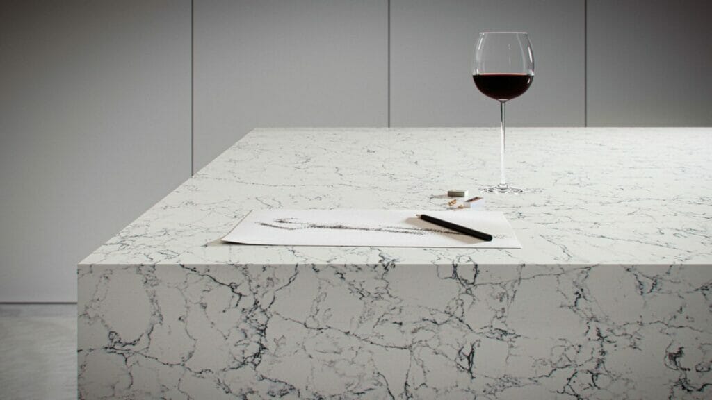 Elegant white Attica countertop with grey and black veining, wine glass, and sketch on the surface.