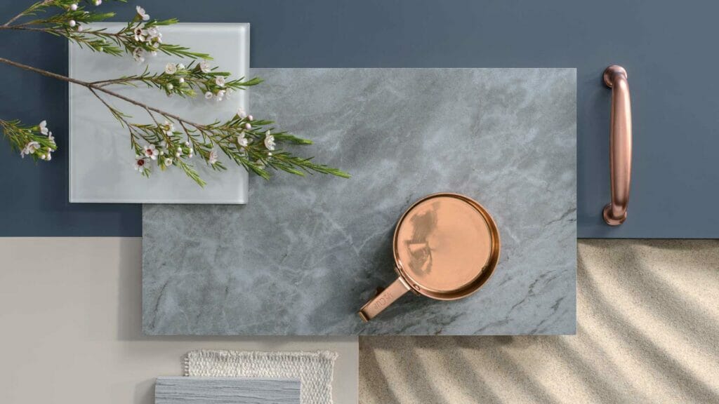 Lush pearl grey slab with bluish undertones and seafoam veining, styled with copper mug and greenery.