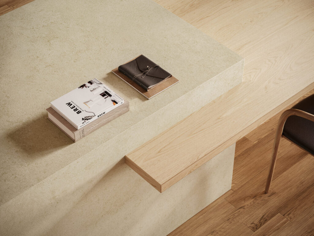 Modern workspace featuring 543 Marenstone surface with neutral tones, books, and natural wood furniture.