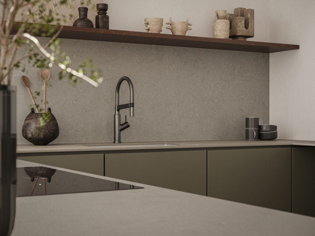 Modern kitchen featuring 544 Auralux stone finish with grey tones, complemented by earthy decor and sleek black faucet.
