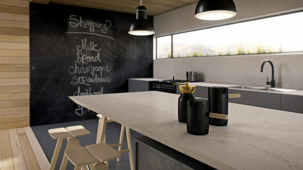 Modern kitchen featuring a large countertop, minimalist decor, and a chalkboard wall with shopping list.
