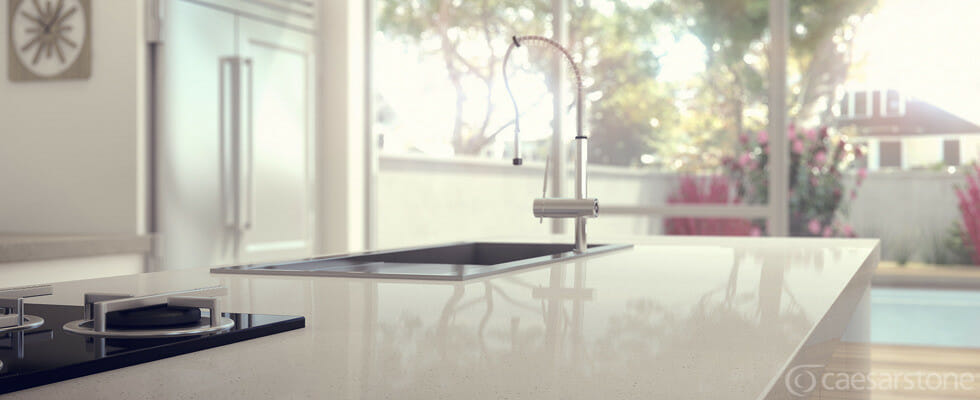 Modern kitchen with a sleek island featuring a deep sink and contemporary faucet, bathed in natural light.