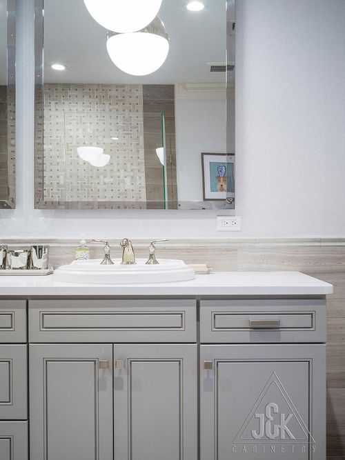 Greige bathroom vanity by J&K, showcasing solid wood construction and modern design with mirrors and sink.