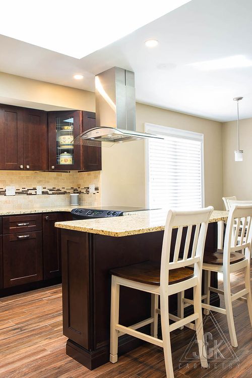 Modern kitchen design featuring J&K's solid wood cabinets and sleek island with bar stools.