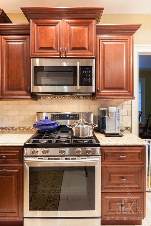 Modern kitchen featuring mahogany cabinets and stainless steel appliances, showcasing J&K's solid wood craftsmanship.