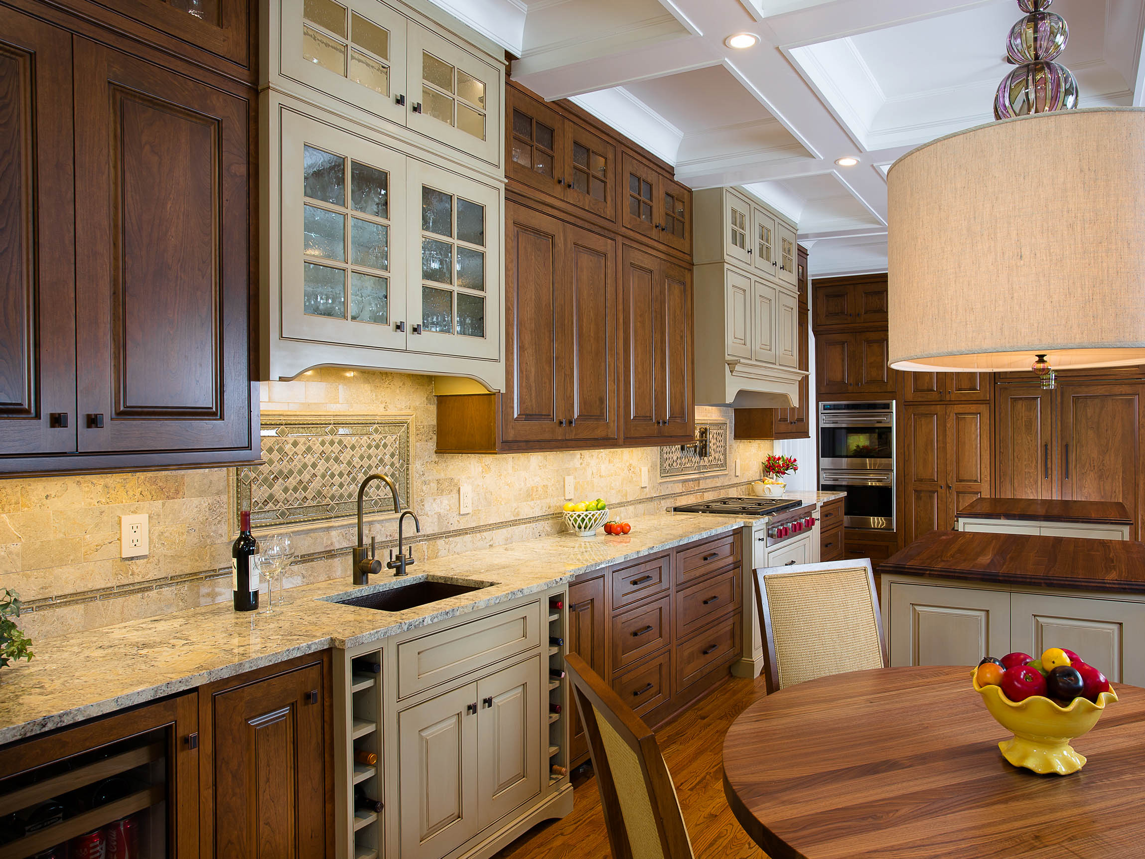 Customizable Shiloh kitchen cabinets in various wood finishes, featuring modern appliances and a stylish dining area.