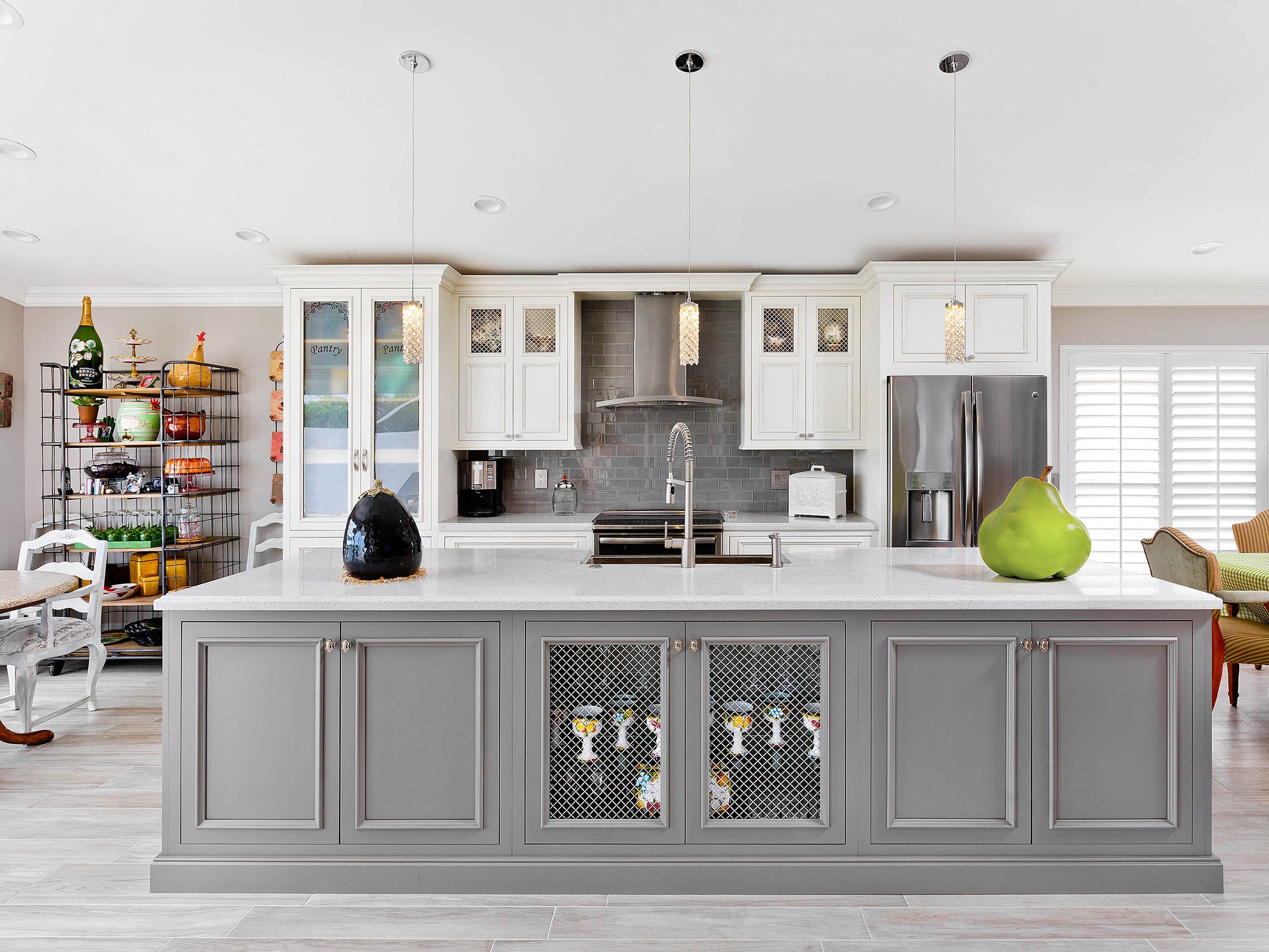 Modern kitchen featuring Shiloh cabinets in gray, with a central island, stylish fixtures, and bright decor.