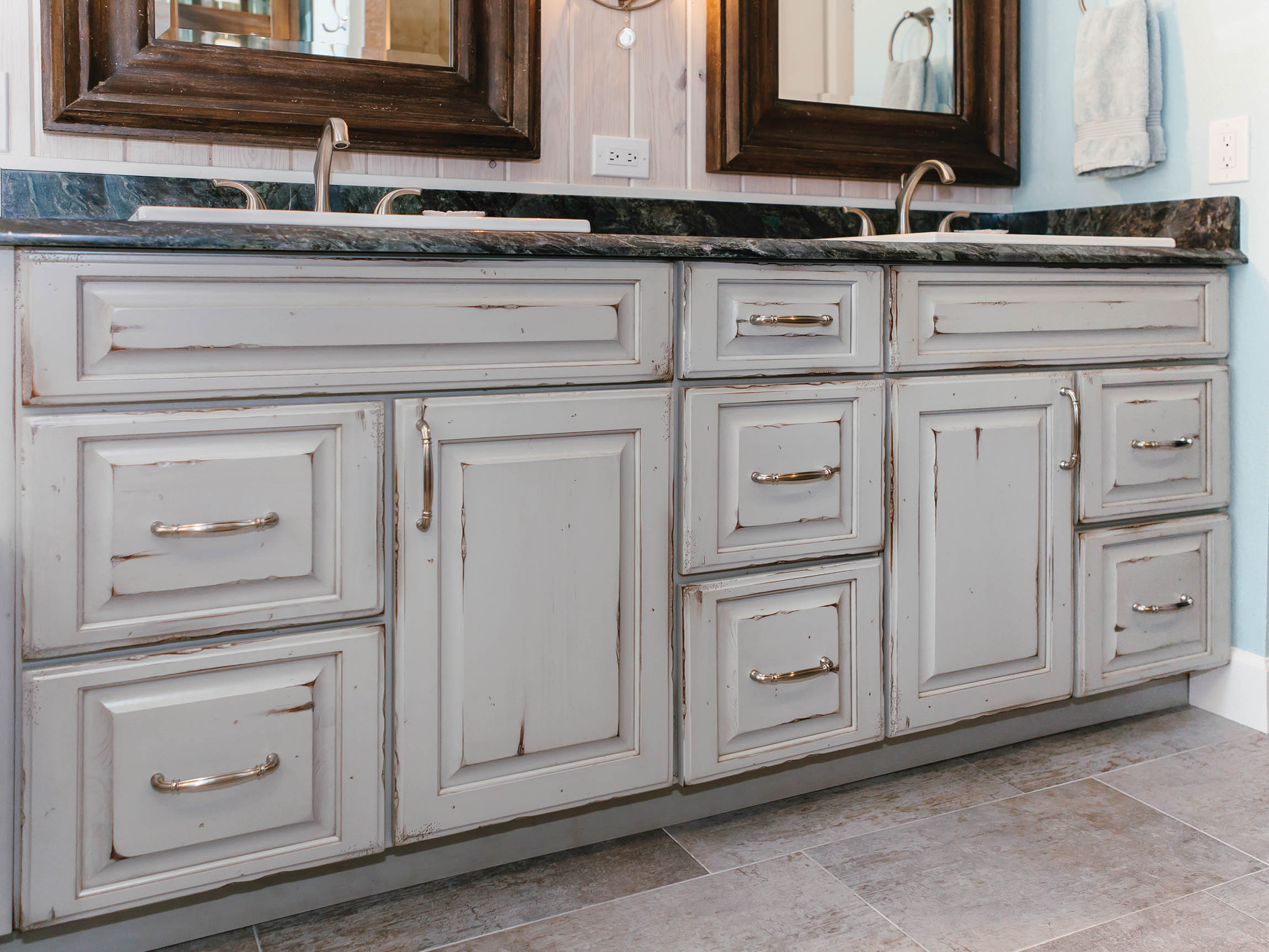 Shiloh square raised cabinet in a bathroom with grey finish and granite countertop, showcasing customizable design options.