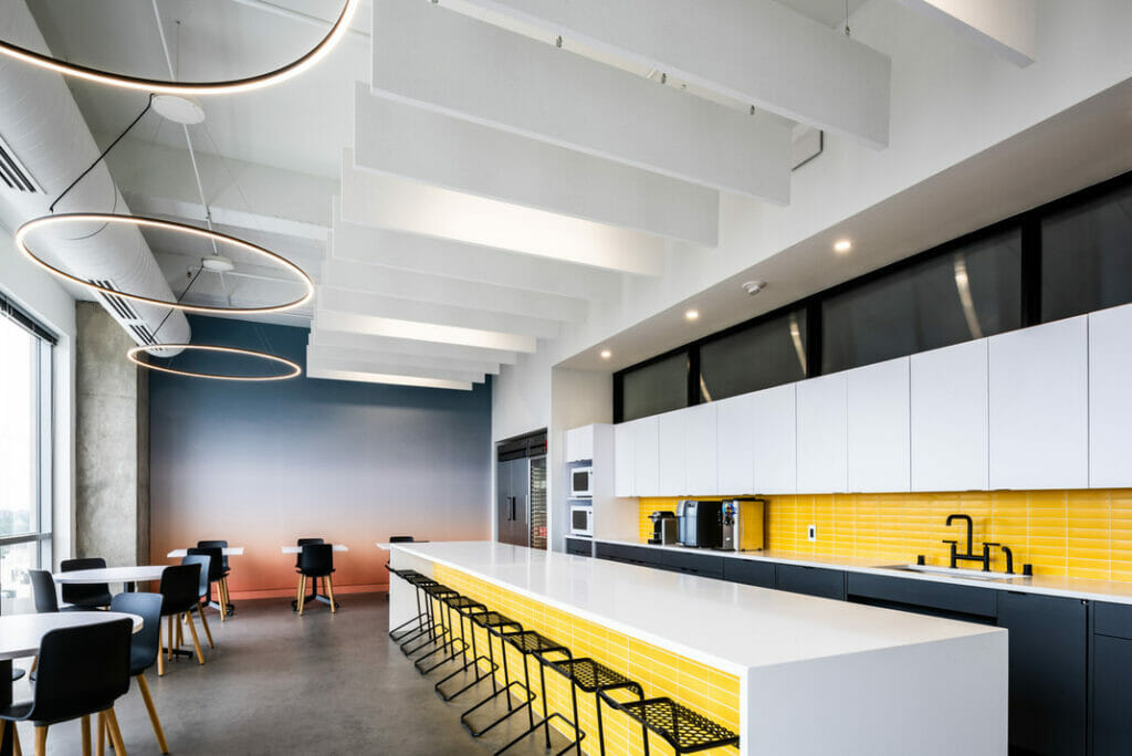 Modern kitchen interior featuring a sleek white countertop, yellow backsplash, and minimalist furniture.