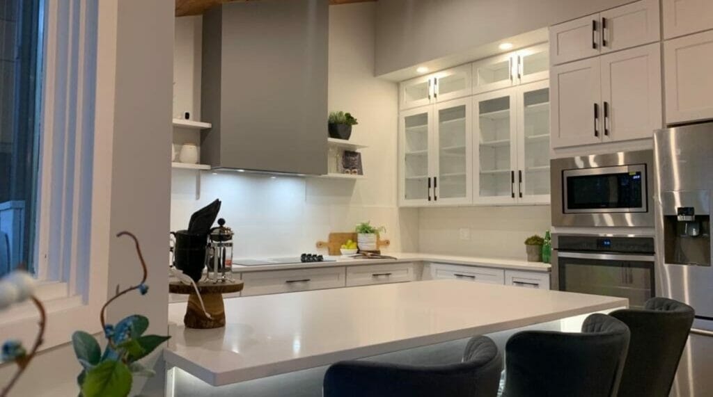 Modern kitchen featuring sleek cabinetry, stainless steel appliances, and a stylish island with dining chairs.