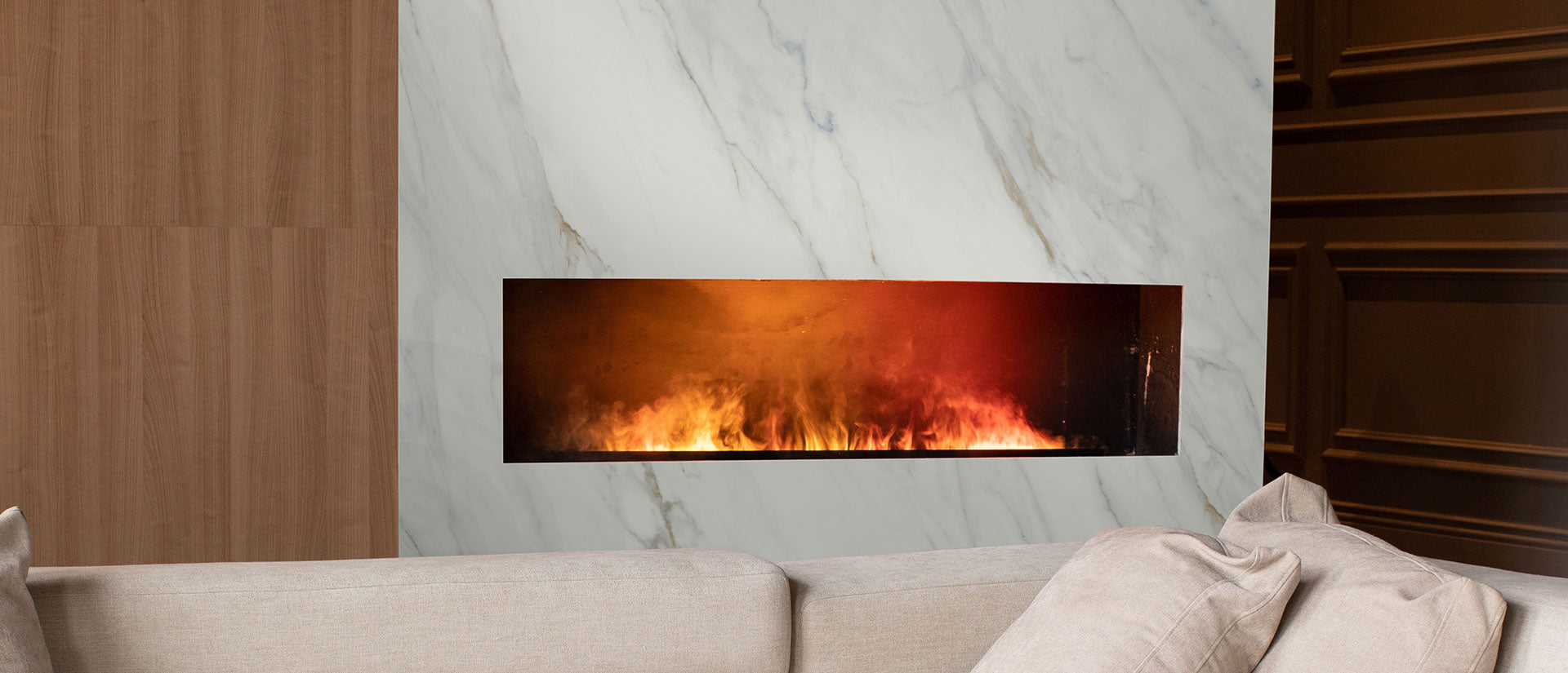 A luxury living and kitchen space featuring Calacatta Lapiza quartz with thick, dramatic charcoal veins on a white surface, showcasing a bold mitered edge island.