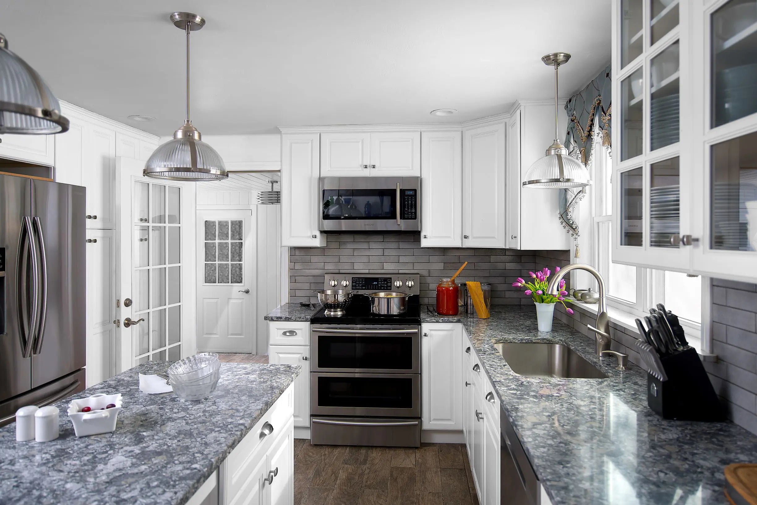 Modern kitchen showcasing Value Premium Hallmark Frost Cabinets with a waterfall island and stainless steel appliances.