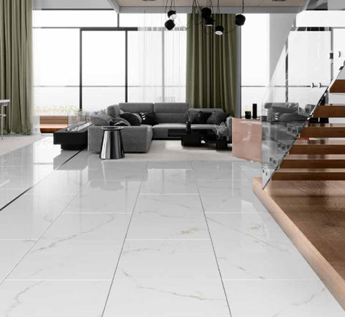 Modern living room featuring polished marble floor tiles, a grey sofa, and stylish glass staircase.