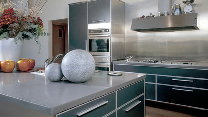 Modern kitchen featuring sleek gray cabinets, stainless steel appliances, and decorative elements for a contemporary aesthetic.