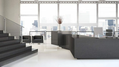 Modern office reception area with sleek black furniture and large windows showcasing skyline views.