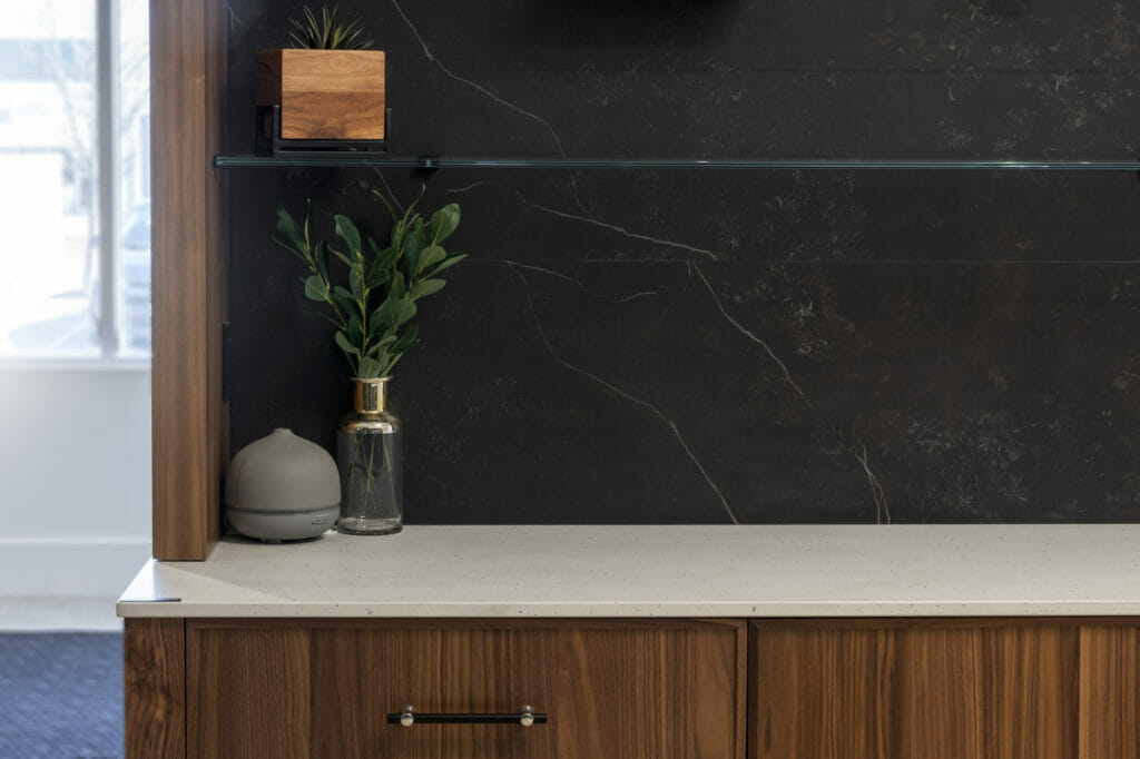 Stylish interior featuring a wooden cabinet, decorative plant, and minimalist decor against a dark wall.