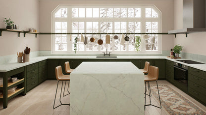 Modern kitchen featuring a pearl-white countertop with dark grey veins, green cabinets, and large windows for natural light.