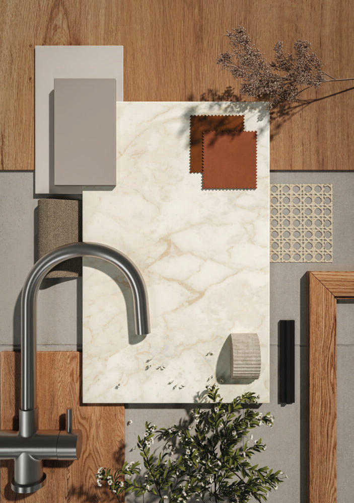 Stylish kitchen countertop with warm white marble, fabric swatches, and modern faucet design in a contemporary setting.