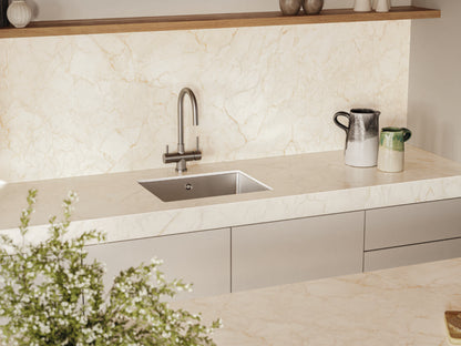 Luxurious kitchen with warm white marble countertop, modern sink, and elegant decor, featuring a sleek design and natural light.
