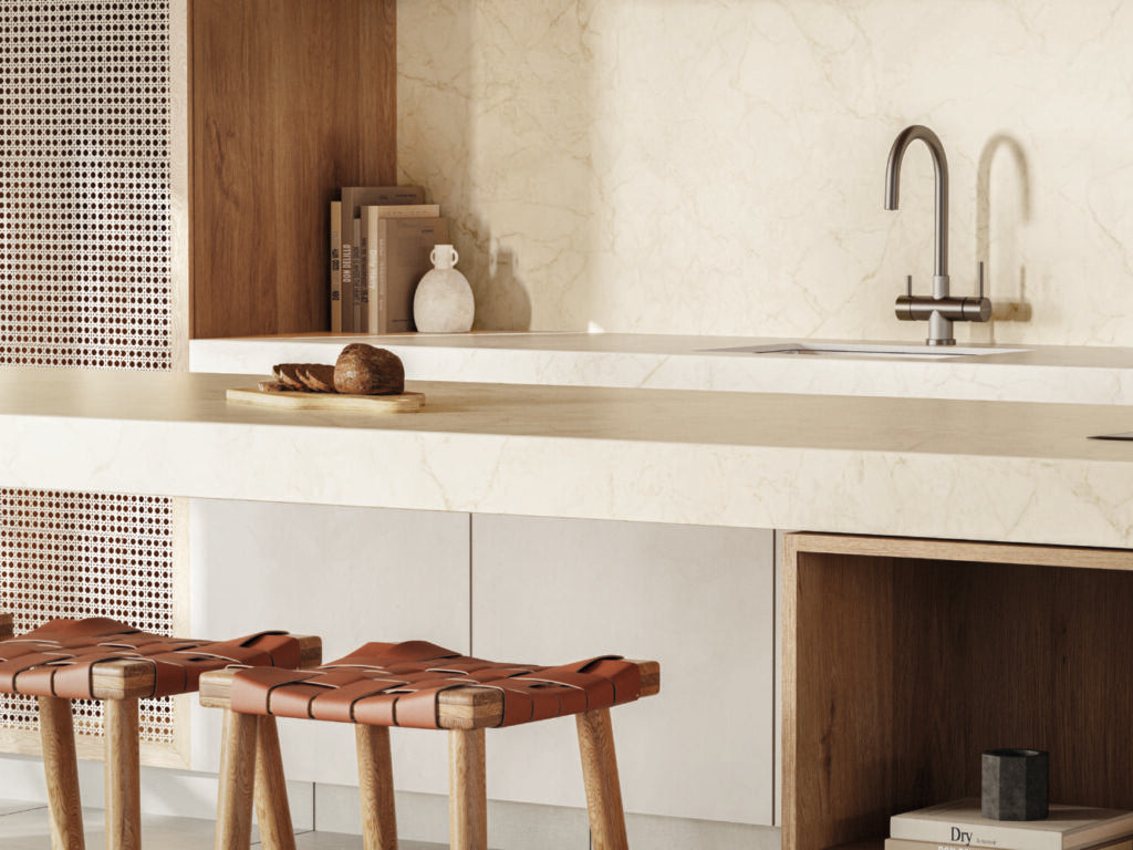 Stylish kitchen featuring a warm white marble countertop, wooden cabinets, and elegant leather stools.