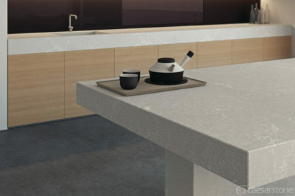 5110 Alpine Mist countertop showcasing cool grey with white veins and dark flecks, styled with modern dishes.