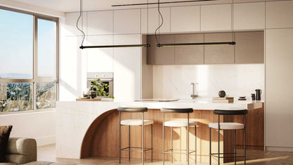 Modern kitchen featuring a white marble island, wooden accents, and stylish bar stools under sleek pendant lighting.