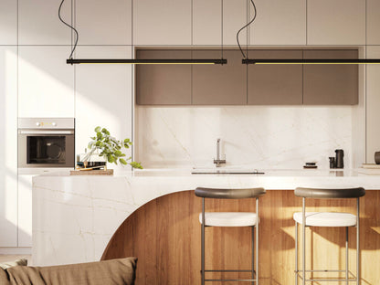 Modern kitchen featuring a white marble island with wooden accents and sleek bar stools, illuminated by contemporary pendant lights.