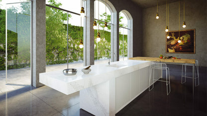Modern kitchen showcasing a Calacatta Nuvo countertop with grey streaks on a creamy-white base, featuring large windows and stylish decor.