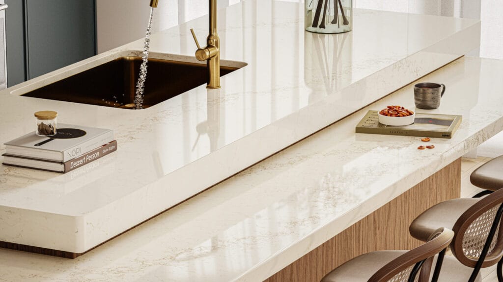 Luxe kitchen featuring creamy white countertop with grey and brown veins, modern sink, and stylish decor elements.