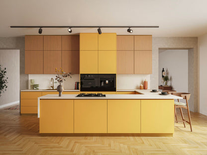 Modern kitchen featuring yellow cabinets, a sleek black stove, and wooden flooring, creating a vibrant and stylish space.
