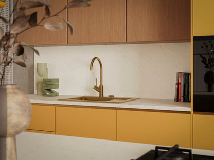Modern kitchen featuring Dreamy Carrara countertop, brass faucet, wooden cabinets, and stylish decor accents.