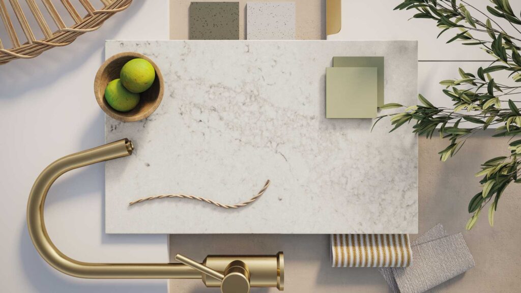Aerial view of a countertop featuring lime green hues, gold faucet, and decorative elements like fruits and fabric swatches.