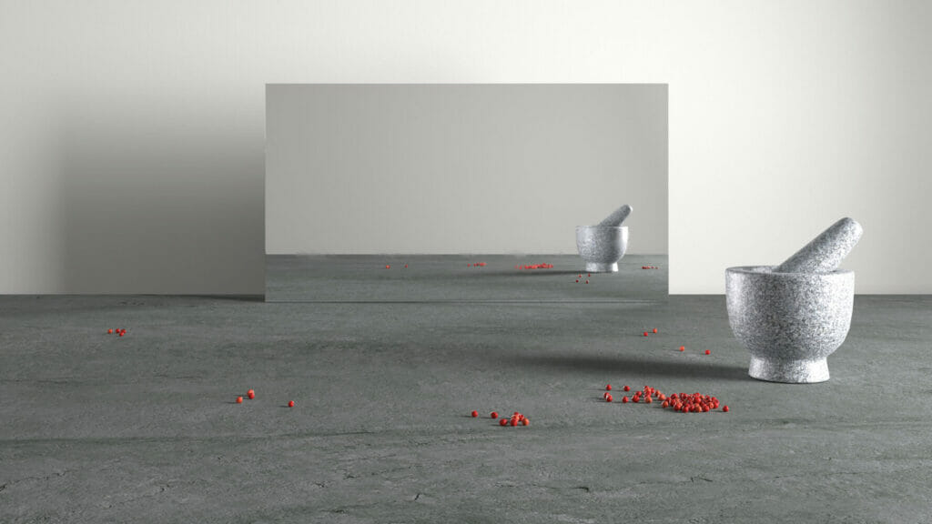 Minimalist scene with a mortar and pestle on a textured gray surface, reflecting in a mirror, with scattered red pepper berries.