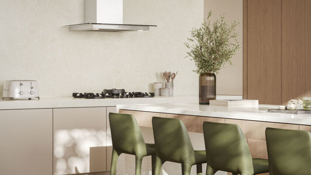 Modern kitchen featuring warm white cabinets, green chairs, and a stylish stovetop, creating a soothing and elegant atmosphere.