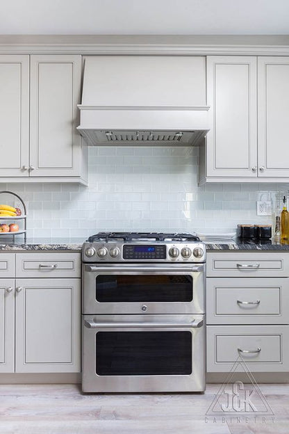 Modern kitchen featuring J&K's greige cabinets and stainless steel appliances, showcasing solid wood construction.