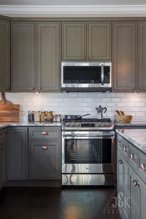 Modern kitchen featuring J&K's solid wood cabinets and stainless steel appliances, showcasing elegance and durability.