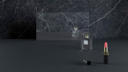 Perfume bottle and pink lipstick on a sleek dark marble countertop with a reflective mirror.