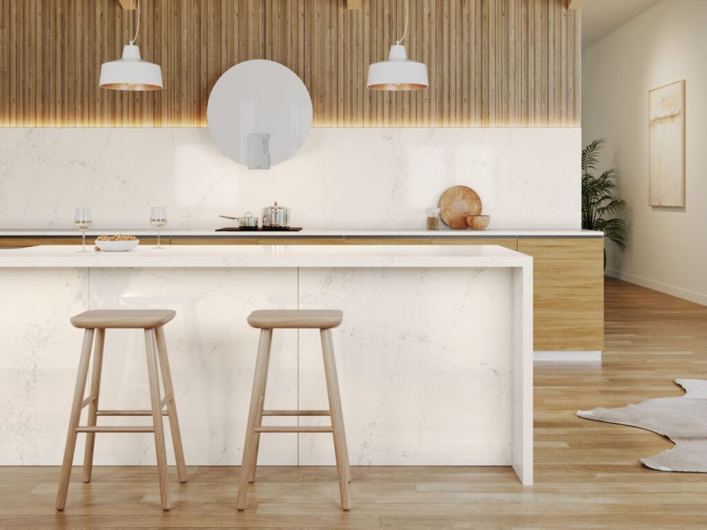 Contemporary kitchen with white marble countertops, wooden accents, bar stools, and warm lighting.