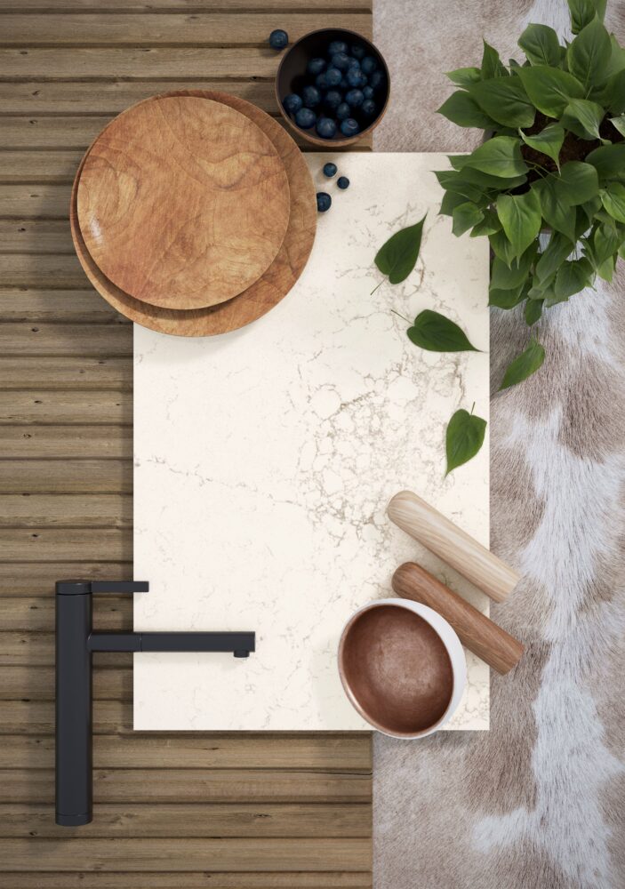 Elegant kitchen countertop with rich milky surface, wooden bowls, blueberries, greenery, and rustic décor accents.